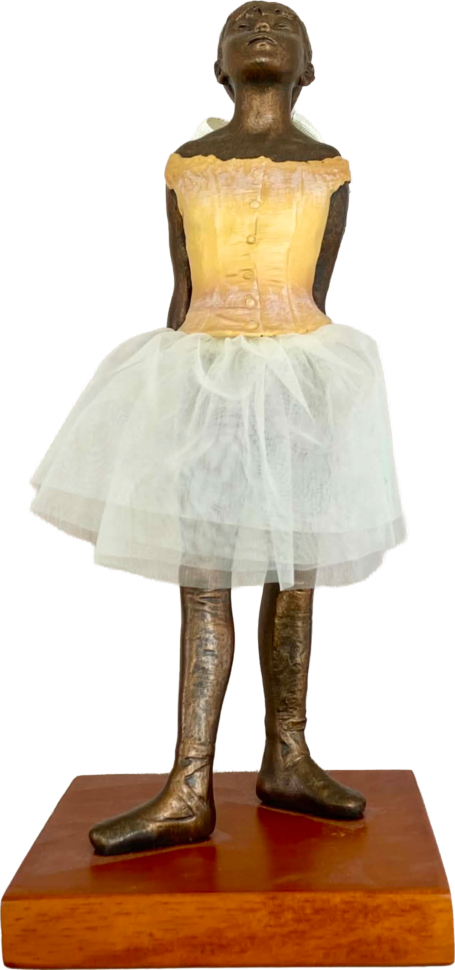 Small sculpture of a dancer wearing a pale tutu on a wooden base.